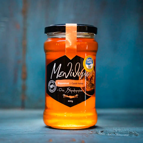 Carob Honig präsentiert bei KRETA natürlich. Eine selten zu findende Spezialität aus den Blüten des Johnanisbrotbaumes.