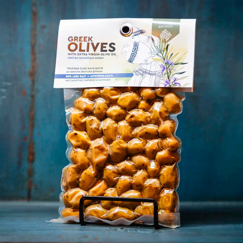 Grüne Oliven mit Kräutern im blauen Ambiente – aromatische mediterrane Oliven verfeinert mit frischen Kräutern, ideal für Salate und Feinschmecker.