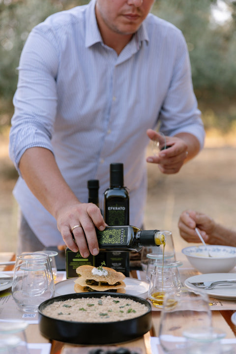 Efkrato-Olivenöl bei der Verkostung – frisch und aromatisch, stilvoll präsentiert auf einem rustikalen Tisch mitten im kretischen Olivenhain