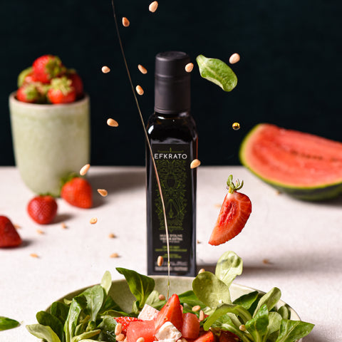Efkrato-Olivenöl-Flasche mit frischen Erdbeeren dekorativ in Szene gesetzt – stilvolle Komposition für kreative mediterrane Küche