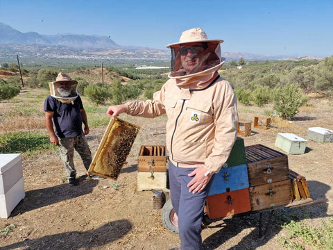 Andreas im Bienenschutzanzug bei der Honigernte – professioneller Imker in der mediterranen Landschaft, der nachhaltig naturreinen Honig gewinnt.